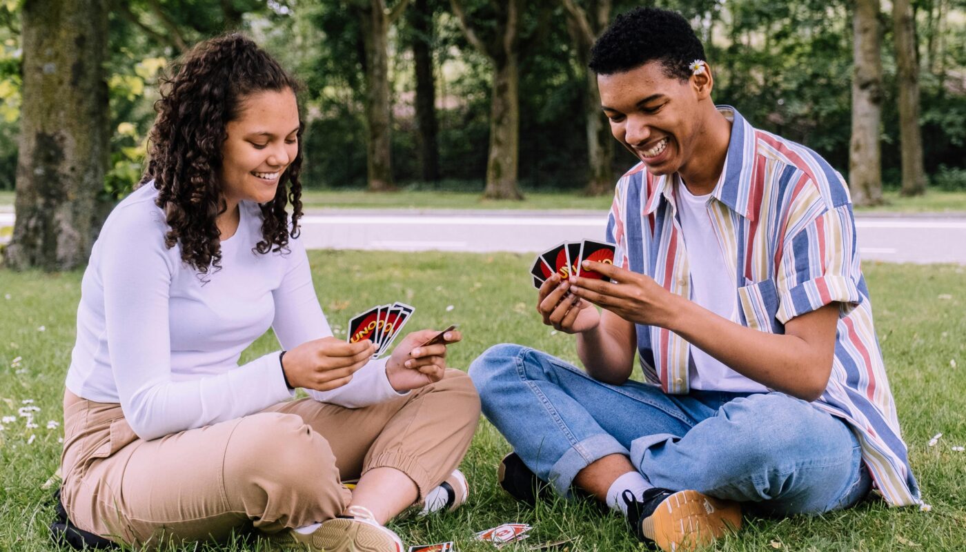 https://www.pexels.com/photo/man-and-woman-sitting-on-grass-playing-cards-2981571/